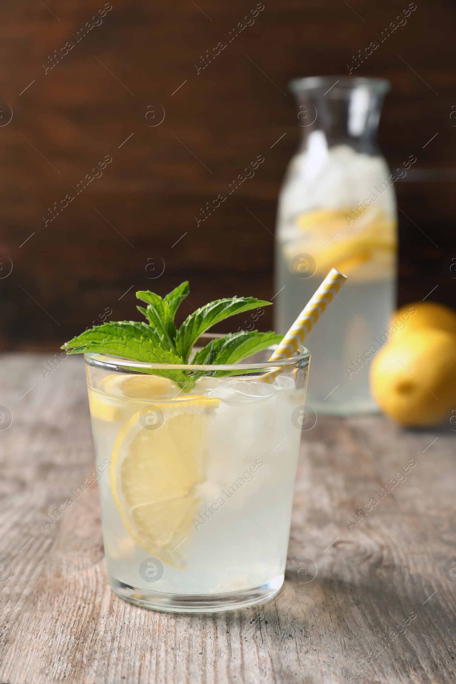 Photo of Natural lemonade with mint in glass on wooden table