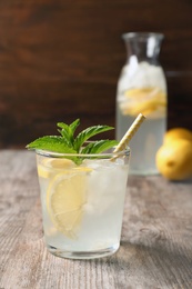 Photo of Natural lemonade with mint in glass on wooden table