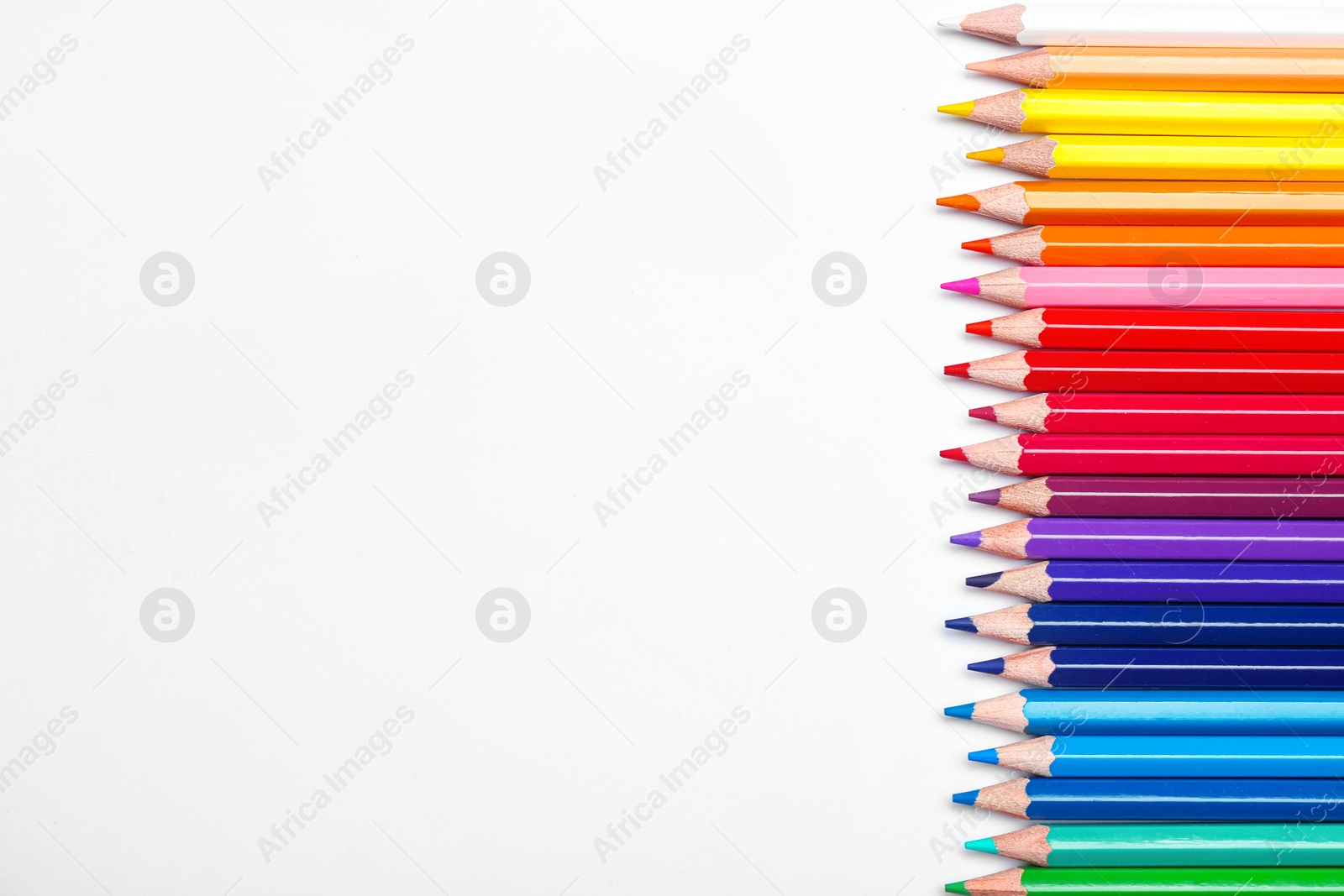 Photo of Color pencils on white background, top view. Space for text