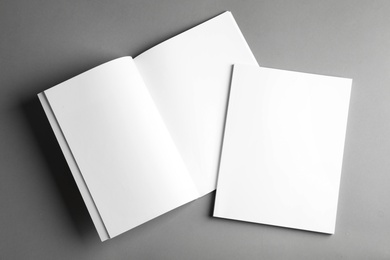 Photo of Open and closed blank brochures on grey background, top view. Mock up for design