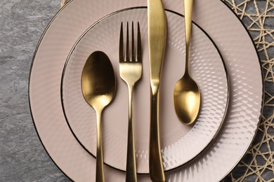 Stylish table setting with cutlery on grey surface, top view