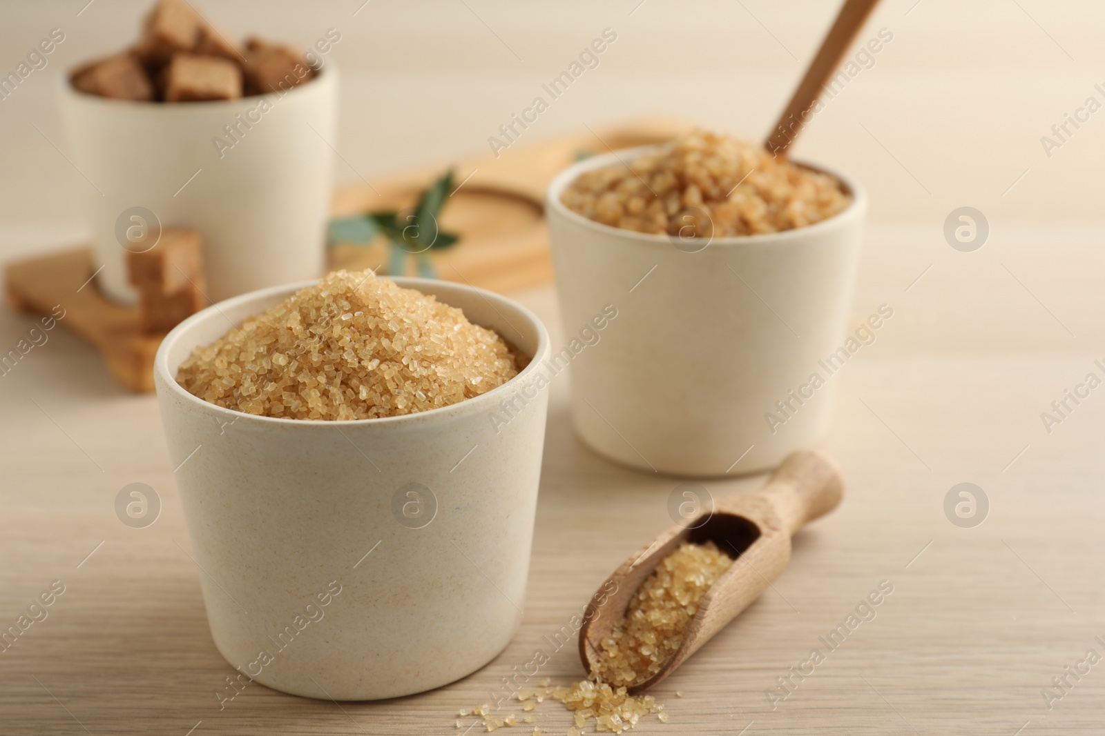 Photo of Bowls with different types of brown sugar on wooden table