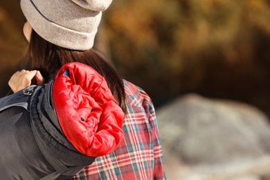 Photo of Female camper with sleeping bag outdoors, closeup. Space for text