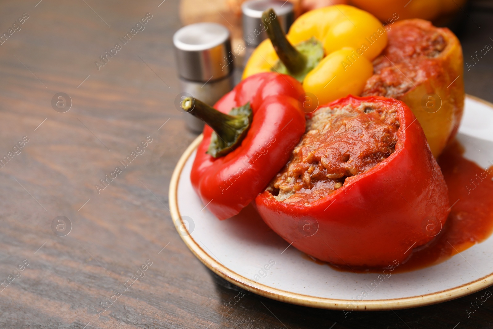 Photo of Delicious stuffed bell peppers served on wooden table, closeup. Space for text