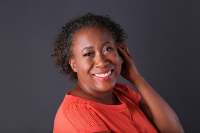 Photo of Portrait of happy African-American woman on black background