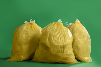 Trash bags full of garbage on green background