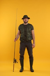 Photo of Fisherman with fishing rod on yellow background