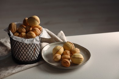 Photo of Walnut shaped cookies on white table, space for text. Homemade pastry filled with caramelized condensed milk