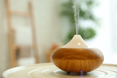 Aroma oil diffuser on table indoors