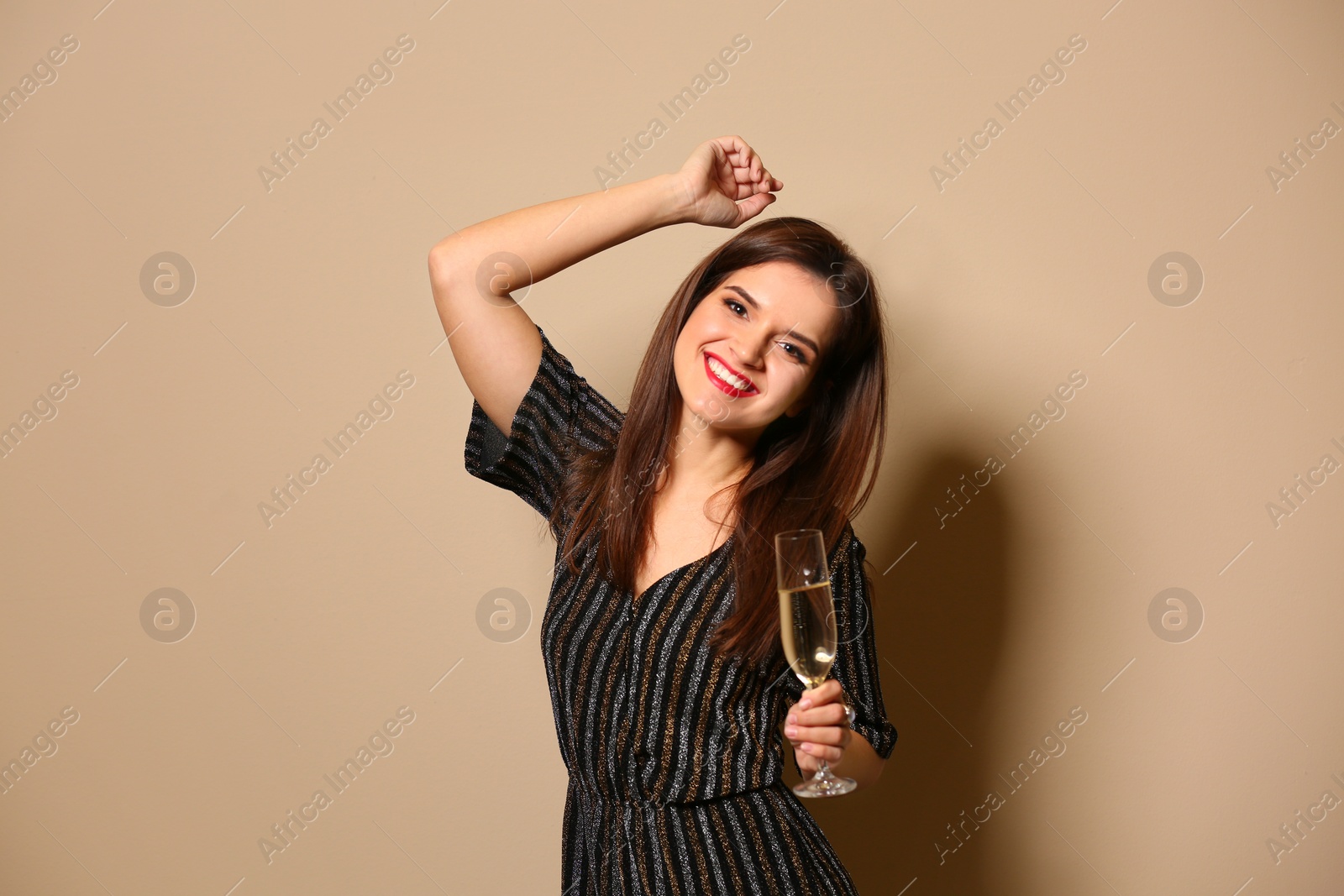 Photo of Portrait of happy woman with champagne in glass on color background