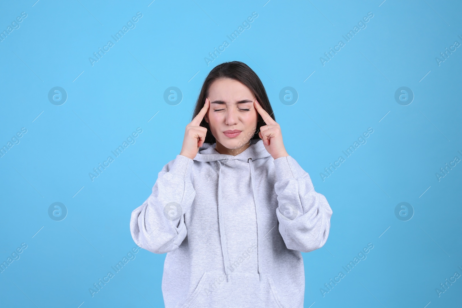 Photo of Portrait of stressed young woman on light blue background