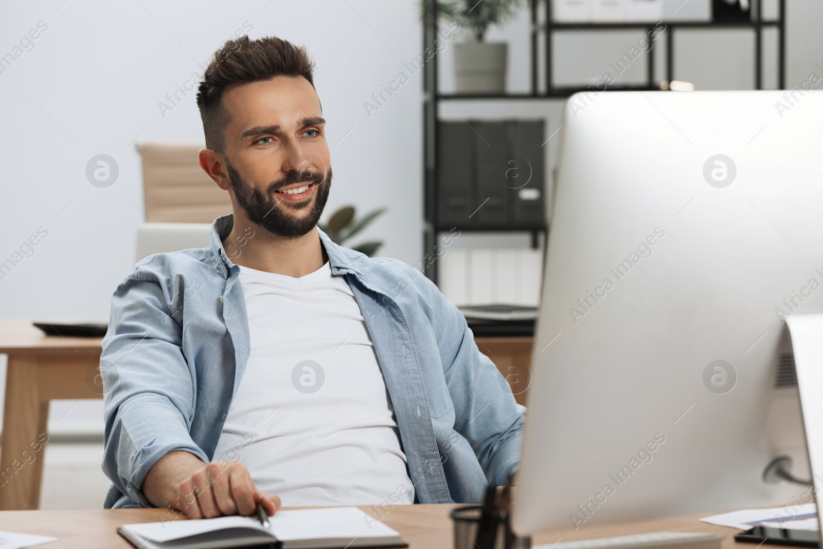 Photo of Man working on computer at table in office