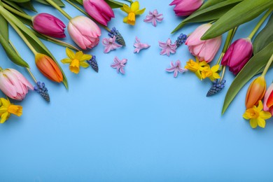 Beautiful flowers on light blue background, flat lay. Space for text