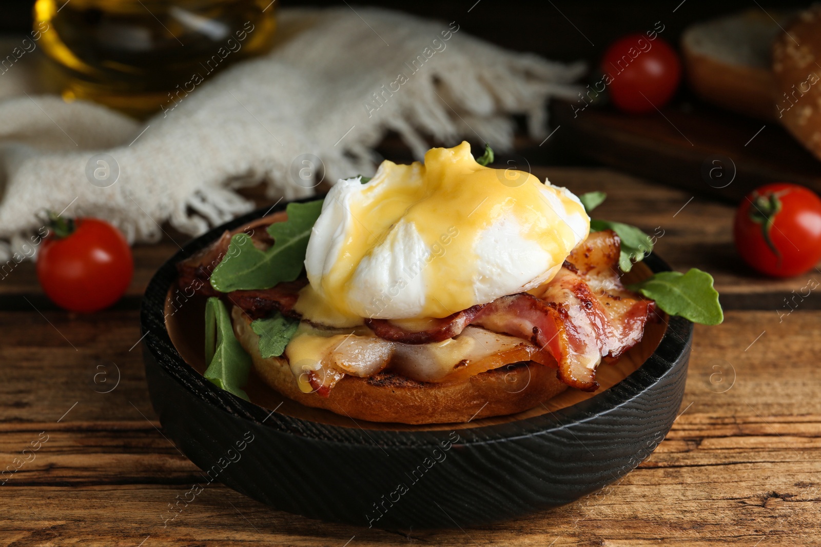 Photo of Delicious egg Benedict served on wooden table