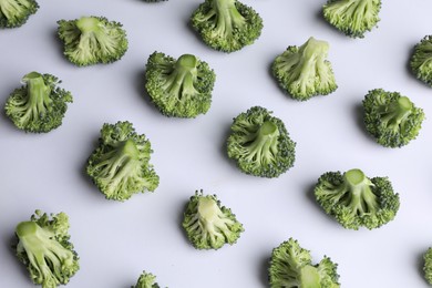 Many fresh green broccoli pieces on white background, above view