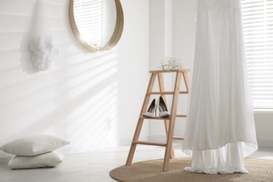 Photo of Beautiful wedding dress, shoes and flowers in room