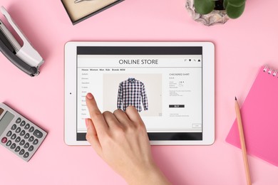 Woman with tablet shopping online on pink background, top view