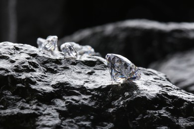 Photo of Different shiny diamonds on wet stone surface