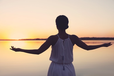 Photo of Woman near river on sunset. Healing concept