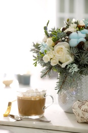 Photo of Beautiful winter wedding bouquet and cup of coffee on white marble table indoors