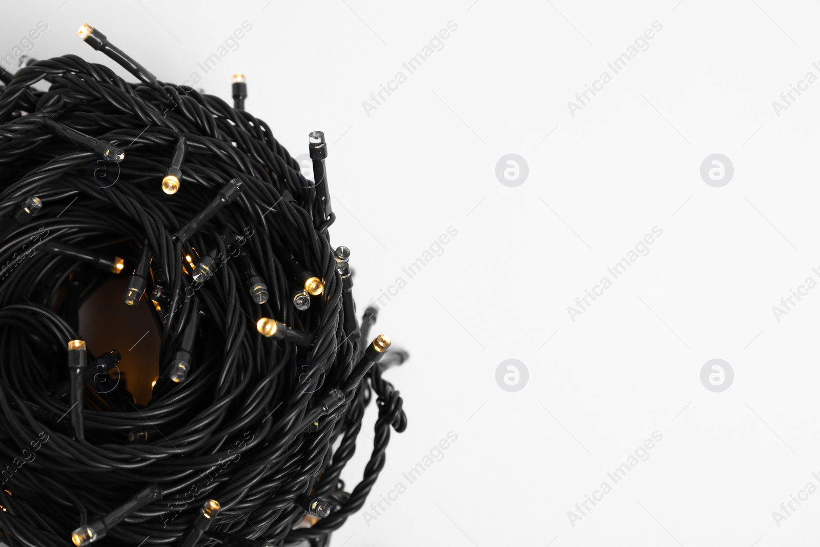 Photo of Beautiful Christmas lights on white background, closeup