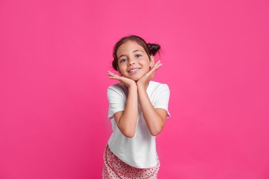 Photo of Cute girl in pajamas on pink background