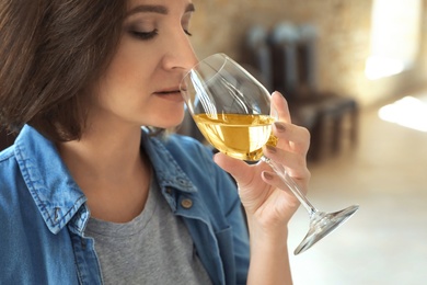 Photo of Woman with glass of white wine indoors, closeup