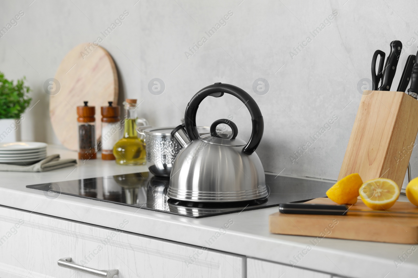 Photo of Stylish kettle with whistle on cooktop in kitchen