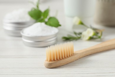 Photo of Toothbrush, dental products and herbs on white wooden table, closeup