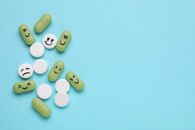 Photo of Different antidepressants with emoticons on light blue background, flat lay. Space for text