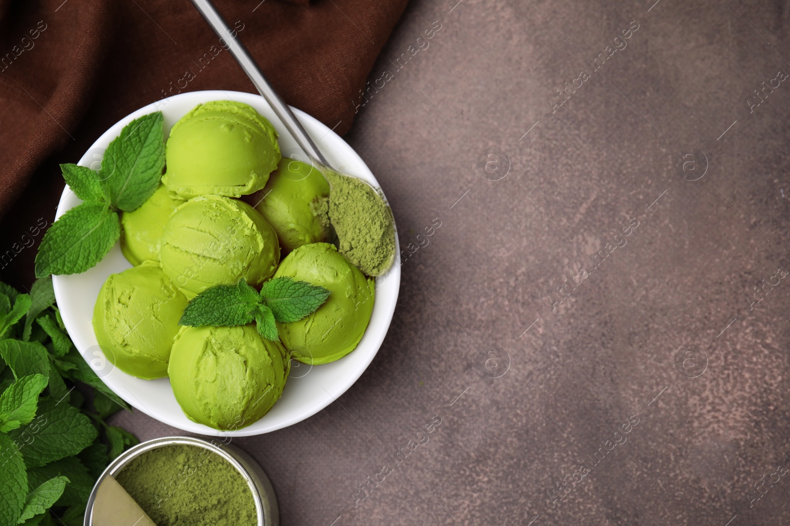 Photo of Tasty matcha ice cream and spoon with powder on brown table, flat lay. Space for text