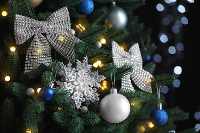 Photo of Beautiful Christmas tree with decor against blurred lights on background