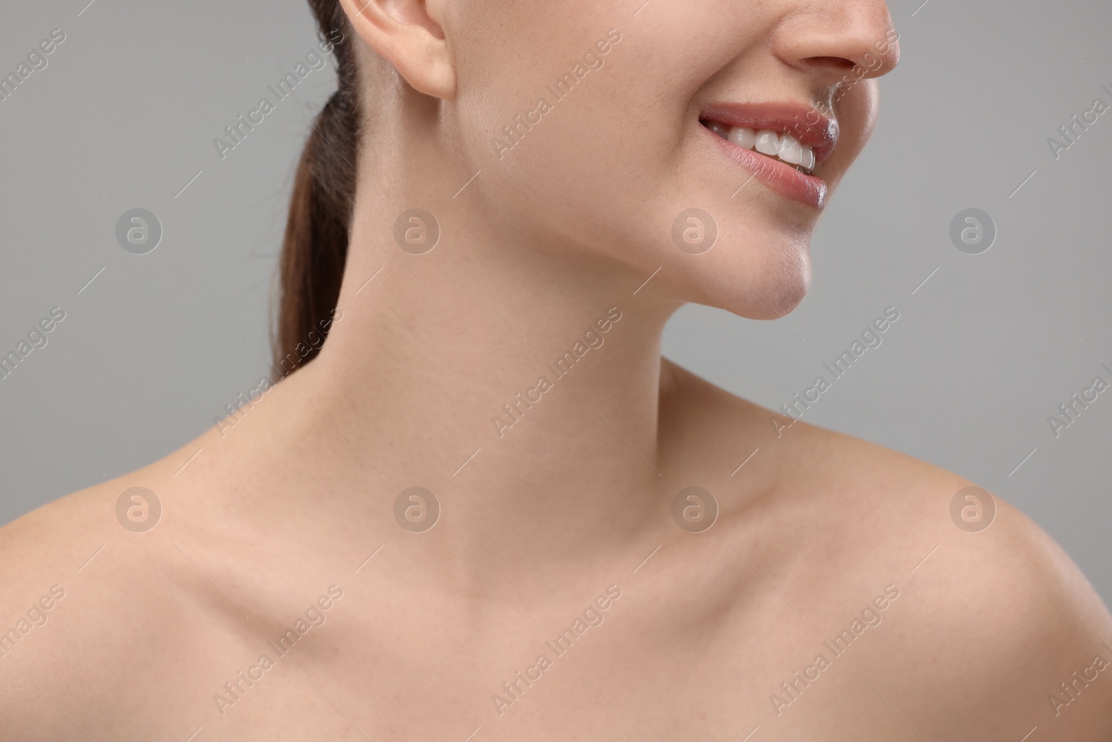 Photo of Beauty concept. Smiling woman on grey background, closeup