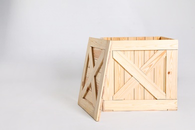 Photo of Open wooden crate on grey background. Space for text