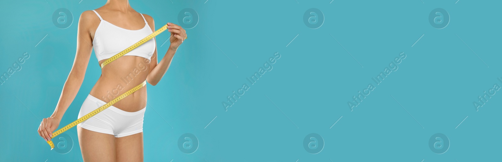 Image of Closeup view of slim woman in underwear with measuring tape on color background, space for text. Banner design