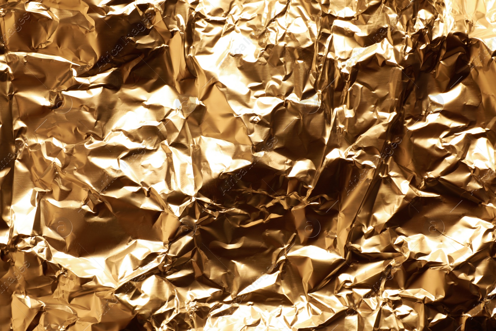 Photo of Crumpled gold foil as background, top view