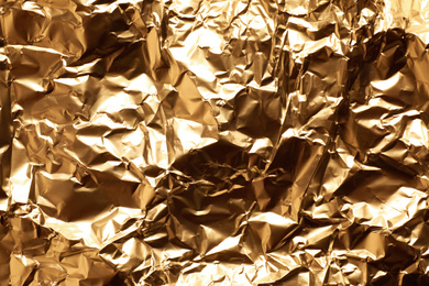 Crumpled gold foil as background, top view