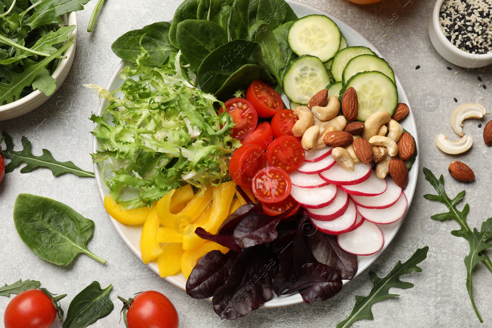 Photo of Balanced diet and vegetarian foods. Plate with different delicious products on grey table, flat lay