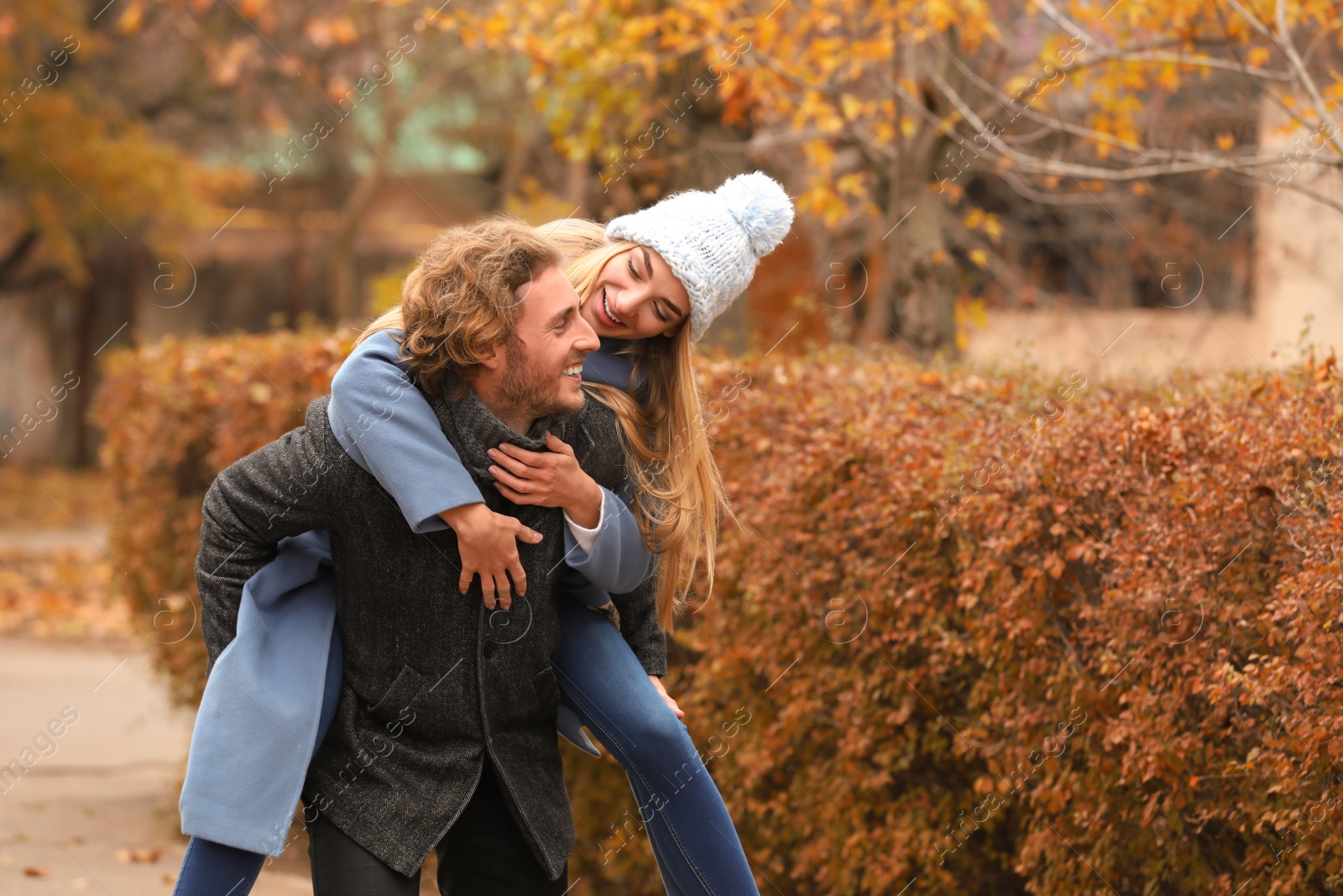 Photo of Young romantic couple having fun in park on autumn day