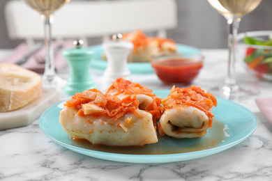 Photo of Delicious cabbage rolls served on white marble table, closeup