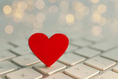 Photo of Decorative heart on laptop keyboard, closeup. Online dating concept