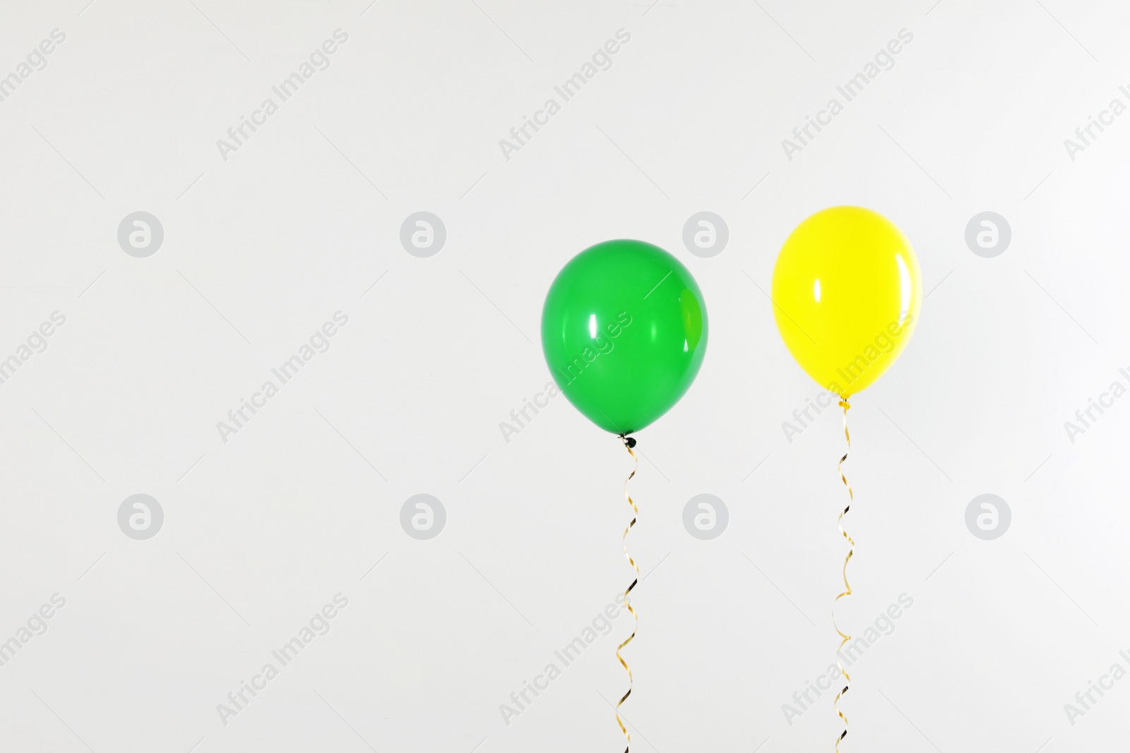 Photo of Different bright balloons on light background, space for text. Celebration time