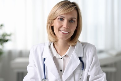 Photo of Portrait of smiling doctor on blurred background