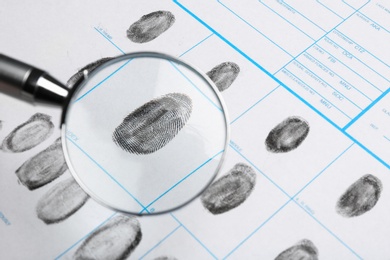 Magnifying glass and criminal fingerprint card, closeup