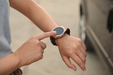 Photo of Young woman with smart watch outdoors, closeup
