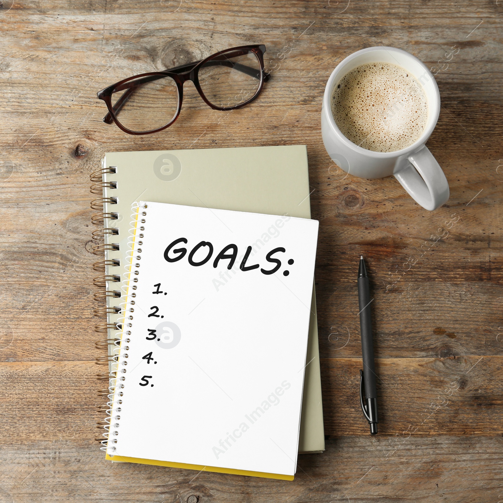 Image of Notebook with inscription New Year Goals, cup of coffee, glasses and pen on wooden table, flat lay. New Year aims 