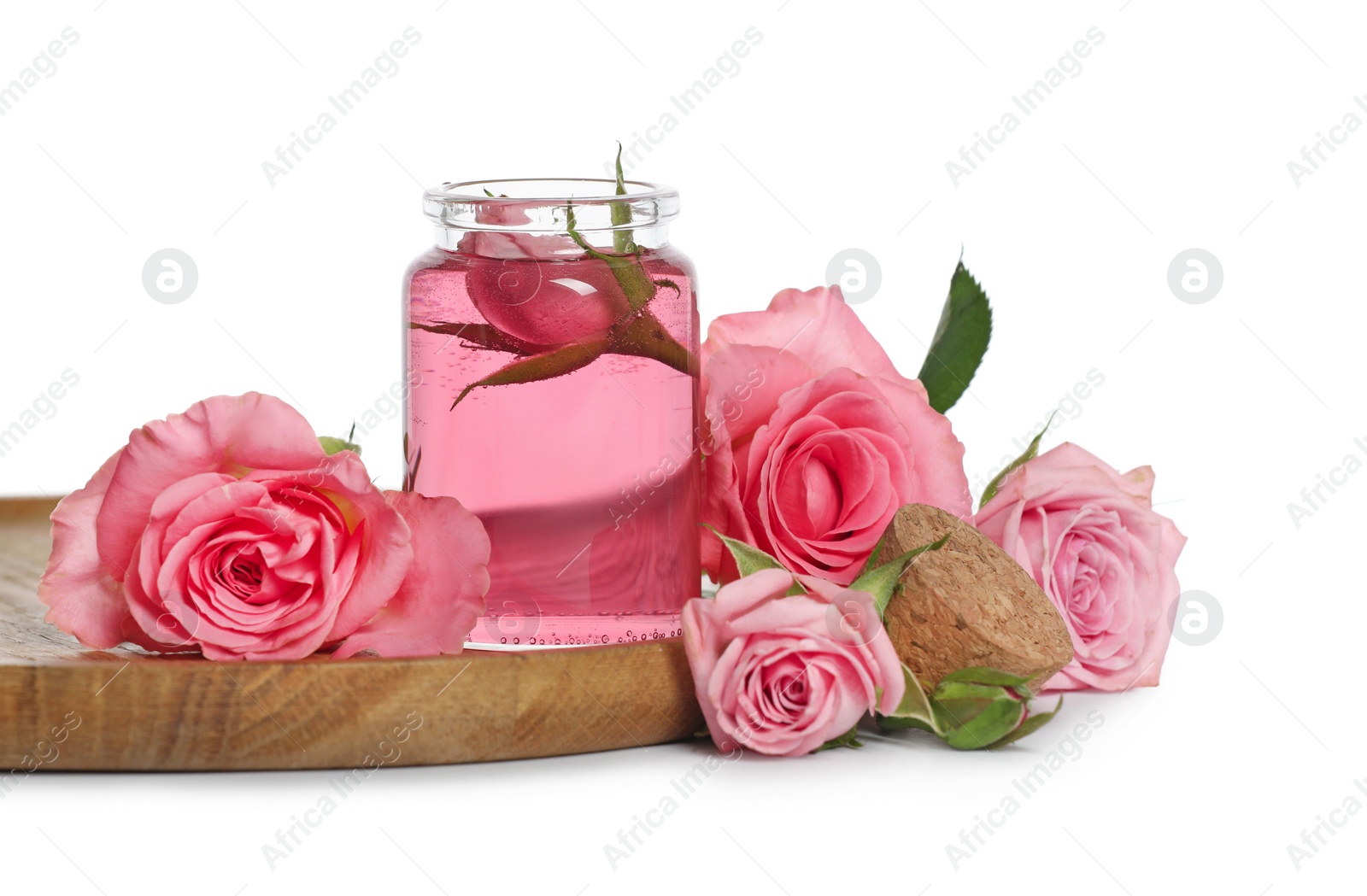 Photo of Bottle of essential rose oil and flowers on white background