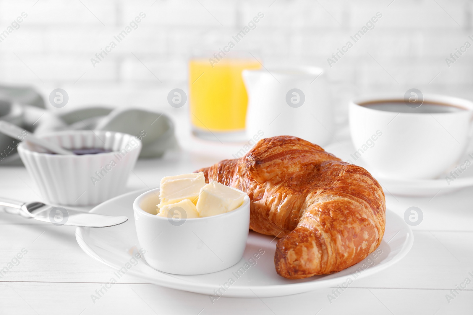 Photo of Fresh croissant and butter on white wooden table. Tasty breakfast