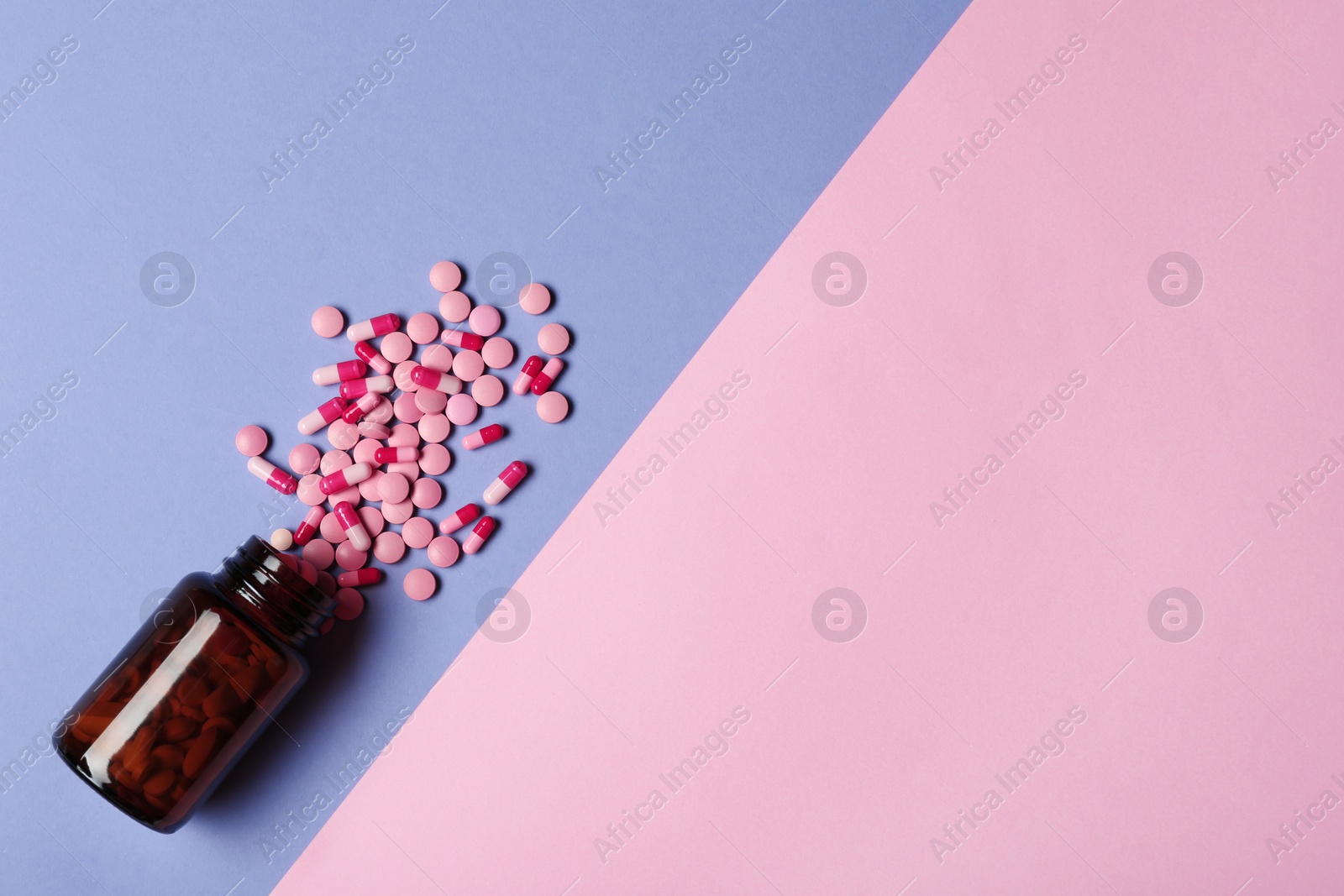 Photo of Bottle with vitamin pills and capsules on color background, flat lay. Space for text