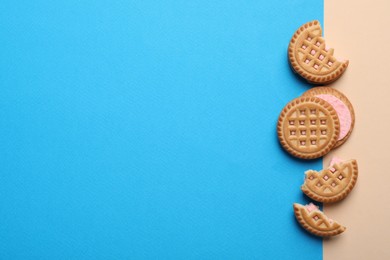 Tasty sandwich cookies with cream on color background, flat lay. Space for text